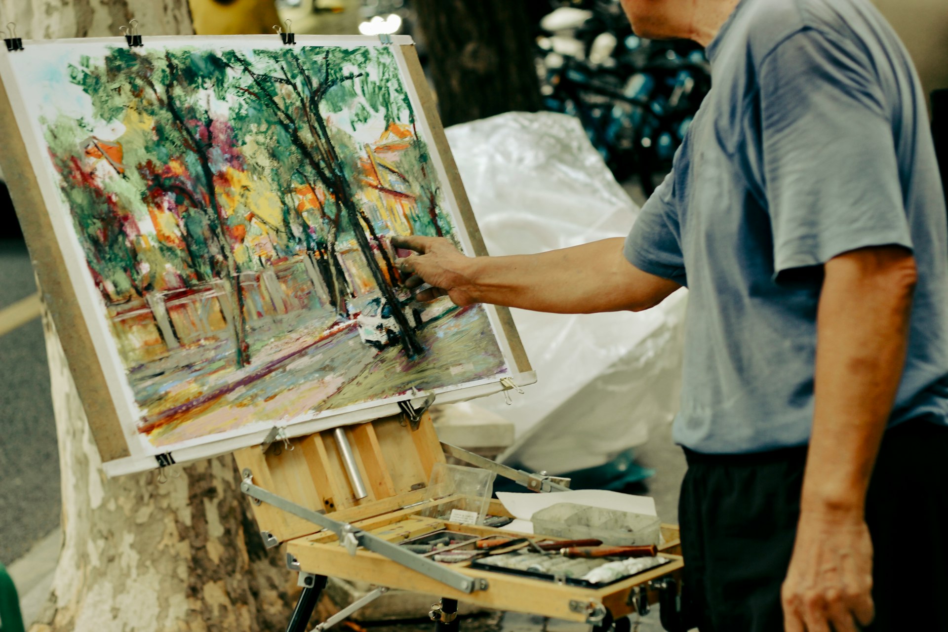 Artist painting a colorful outdoor scene on easel